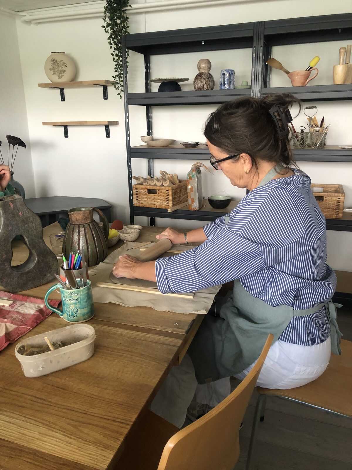 Kiki rollt Ton im Atelier aus